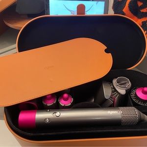 Dyson Airwrap with many attachments and a leather box.
